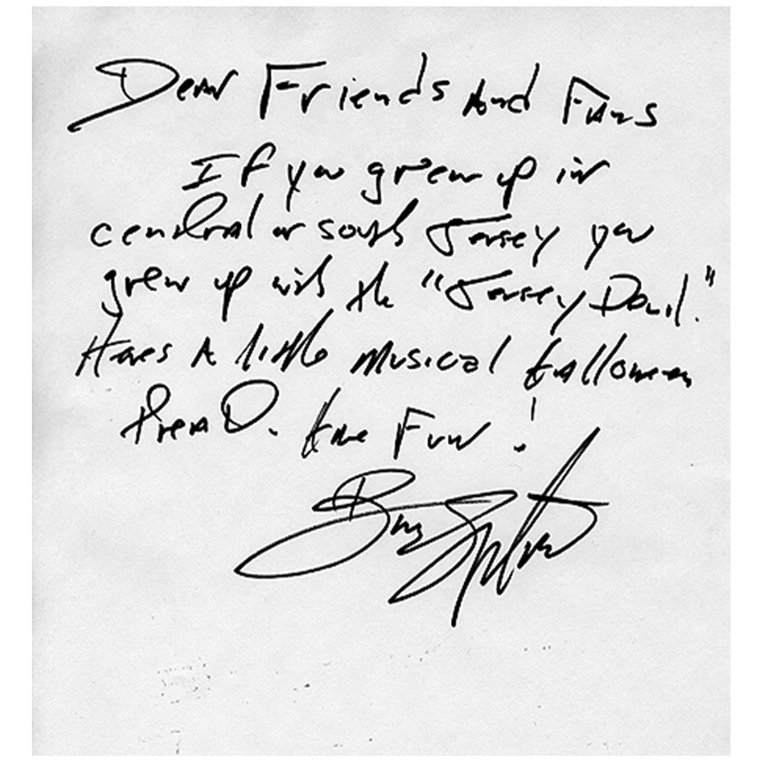 Handwritten note on white paper with black ink. The message references the "Jersey Devil," hints at musical themes, and invites fun. Includes a signature.