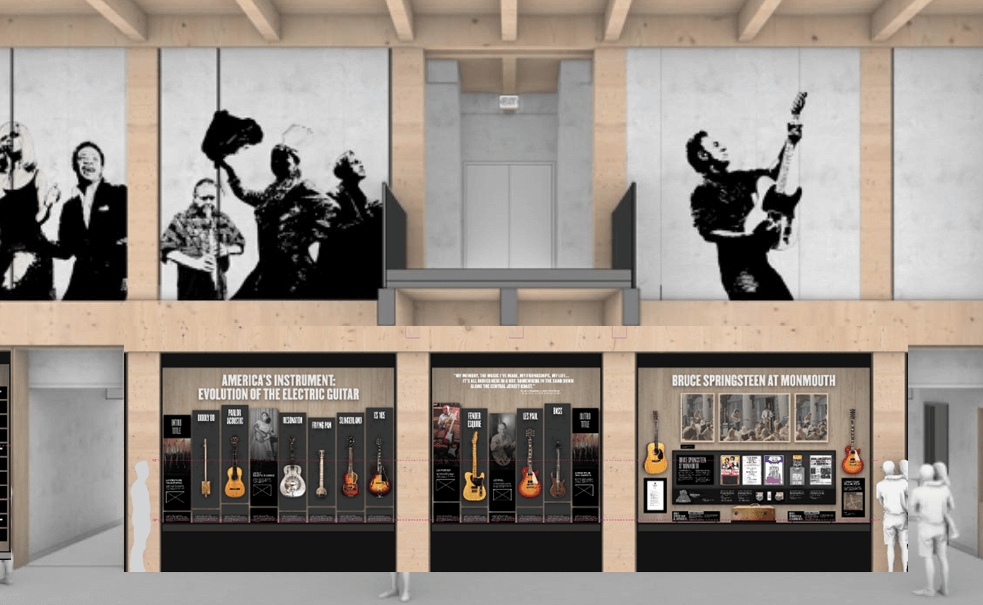 Exhibition space featuring large monochrome murals of musicians above displays. Below, panels showcase the evolution of electric guitars and Bruce Springsteen, with visitors observing.
