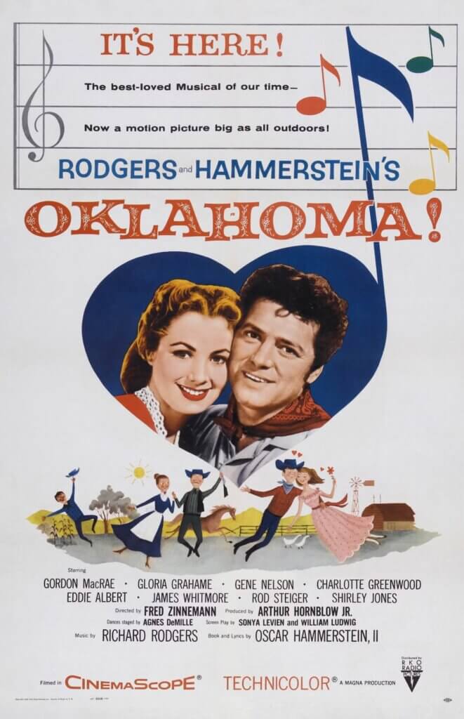 Poster for "Oklahoma!" featuring a smiling couple inside a heart against a blue sky. Below are cheerful dancers, musical notes, and playful colors, conveying a joyful tone.
