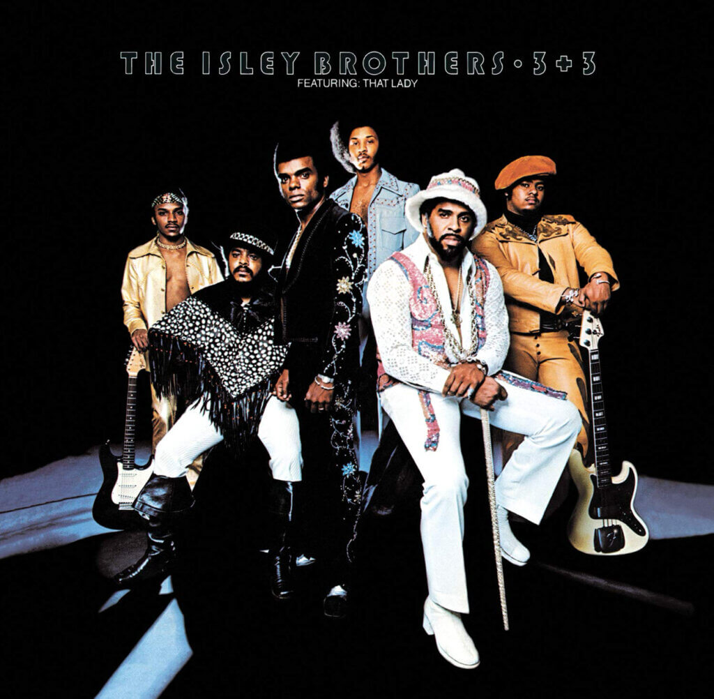 Album cover of "The Isley Brothers: 3+3" features six men in colorful, stylish 1970s outfits, exuding confidence and coolness on a dark background.