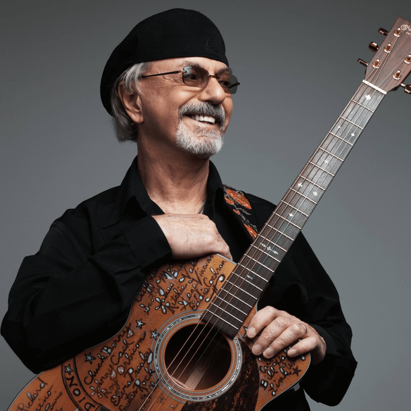 Photo of Dion Dimucci holding a guitar