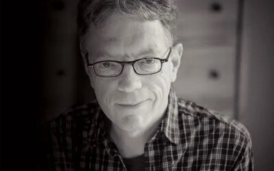 bw photo of a white man with glasses with plaid shirt